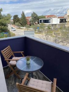 - Balcón con mesa pequeña y sillas en Apartment Lena, en Vodice