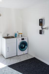 a washing machine in a room with a sink at Riccarton 2 bed 1 bath w/garage in Christchurch