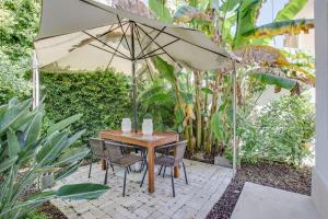 a table and chairs with an umbrella in a garden at White and Light House in Costa da Caparica