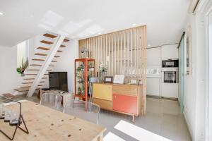 uma sala de estar com uma mesa e uma cozinha em White and Light House em Costa da Caparica