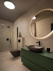 uma casa de banho com um lavatório, um WC e um espelho. em Rooms "Limes" em Funtana