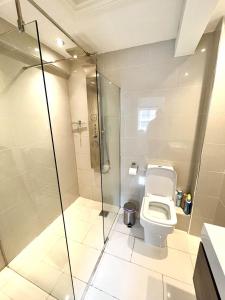 a bathroom with a toilet and a glass shower at Modern 1 Bedroom flat close to Vauxhall in London