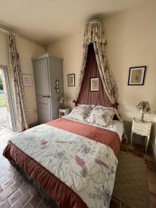 a bedroom with a large bed with a canopy at Chateau d' Emalleville in Émalleville