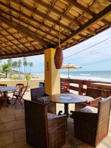 un patio con tavoli, sedie e spiaggia di Bangalô Panorâmica a Conde