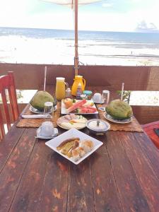 un tavolo con piatti di cibo sulla spiaggia di Bangalô Panorâmica a Conde