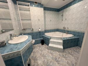 een badkamer met een bad en een wastafel bij Osiedle Leśne 37/28 in Oborniki