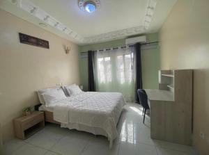 um quarto com uma cama, uma secretária e uma janela em Primeshare Luxury Apartments for Family Travelers with Swimming Pool, Yaounde em Iaundé