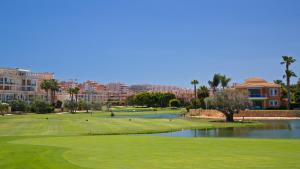 un campo de golf con un verde y un estanque en Casa Domínguez, en Alicante