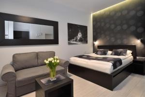 a bedroom with a bed and a couch and a chair at Urban Spirit Apartment in Budapest