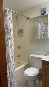 a bathroom with a white toilet and a shower at Den Mishka - Kodiak's Den of the Little Bear in Kodiak