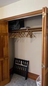 Cette chambre dispose d'un placard avec une étagère en bois. dans l'établissement Den Mishka - Kodiak's Den of the Little Bear, à Kodiak