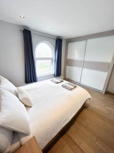 a bedroom with a large white bed with a window at Modern 1 Bedroom flat close to Vauxhall in London