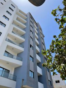 un alto condominio bianco con alberi in primo piano di Go to the top a Dakar