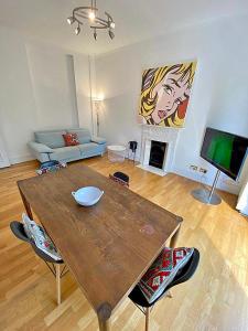 a living room with a wooden table and a couch at Amazing holidays home with a terrace in London
