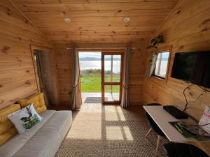 a living room with a couch and a tv in a cabin at Laurels Retreat in Mangonui