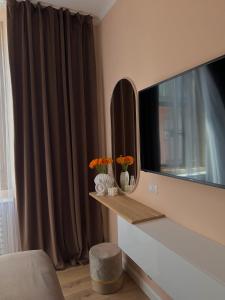 sala de estar con espejo y TV en Rhospitality - Visconti Affittacamere, en Rho