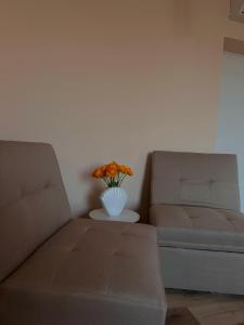 un soggiorno con divano e vaso con fiori di Rhospitality - Visconti Affittacamere a Rho