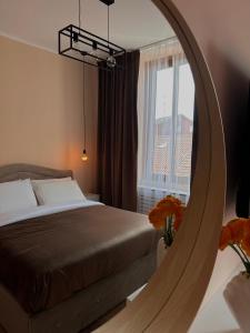 1 dormitorio con cama y espejo en Rhospitality - Visconti Affittacamere, en Rho