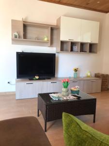 ein Wohnzimmer mit einem TV und einem Couchtisch in der Unterkunft Villa Lory in Terrasini
