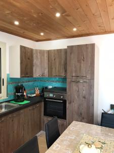una cocina con armarios de madera y una mesa con sillas. en Villa Lory, en Terrasini