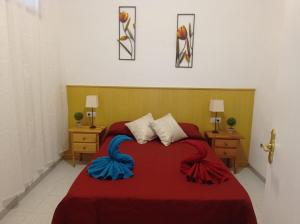 1 dormitorio con 1 cama roja y 2 mesitas de noche en Casa Domínguez, en Alicante