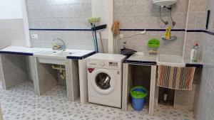 een badkamer met een wasmachine en een wastafel bij Casa Domínguez in Alicante