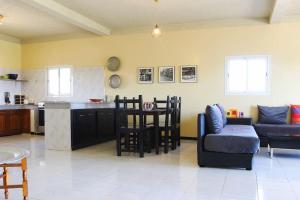 a kitchen and living room with a couch and a table at La petite maison sur la colline - Benslimane 