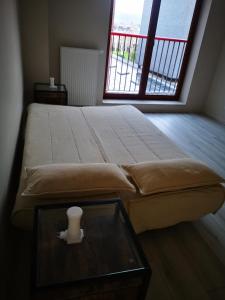 Schlafzimmer mit einem Bett mit einem Glastisch und einem Fenster in der Unterkunft Apartament Sfera in Bielsko-Biała
