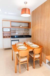 a kitchen with a wooden table with chairs and a dining room at Aqualand Park Resort in Salinópolis