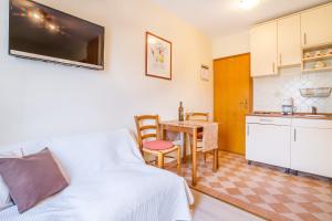 a living room with a couch and a table and a kitchen at STUDIO in Omišalj