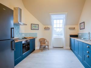 a kitchen with blue cabinets and a sink at Glen Apartment - Uk43813 in Ardovie