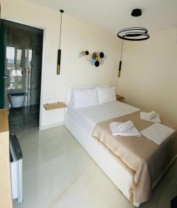 a bedroom with a large white bed with towels on it at Cocoon Hotel-Beach bar in Sarti