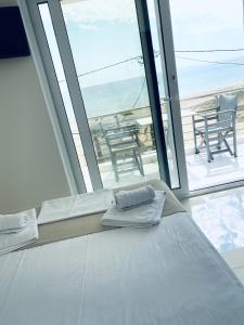 a bed in a room with a view of the ocean at Cocoon Hotel-Beach bar in Sarti