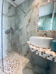 W łazience znajduje się umywalka i prysznic. w obiekcie Cocoon Hotel-Beach bar w mieście Sarti