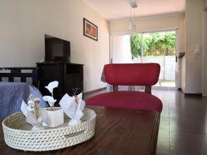 ein Wohnzimmer mit einem Bett und einem roten Stuhl in der Unterkunft La Suite in Chascomús