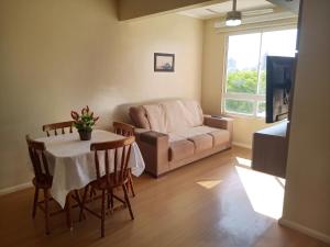 a living room with a table and a couch at AP Moderno in Pelotas