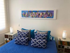 a bedroom with a blue bed with blue pillows at Marquis Enclave, Condo With Pool Access and More in Ricaurte