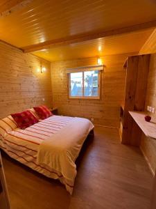 ein Schlafzimmer mit einem Bett in einer Holzhütte in der Unterkunft Casa da Praia in Carvalhal