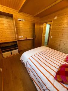 1 dormitorio con 1 cama en una habitación de madera en Casa da Praia, en Carvalhal