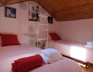 duas camas num quarto com vermelho e branco em White House Lisbon Hostel em Lisboa