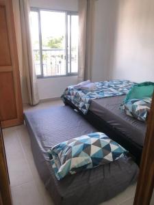 two beds sitting in a room with a window at Hermoso apartamento en Doradal Antioquia in Doradal