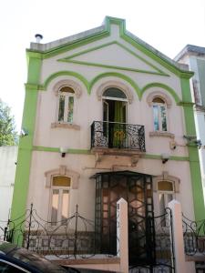 an old house with a balcony on a street at White House Lisbon Hostel in Lisbon