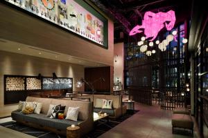 a lobby of a hotel with couches and a restaurant at Moxy Osaka Shin Umeda in Osaka