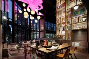 a restaurant with tables and chairs and a large window at Moxy Osaka Umeda in Osaka