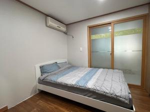 una piccola camera da letto con un letto e una finestra di Sangmin Sweet a Daejeon