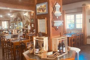 un restaurante con mesas, sillas y botellas de vino en Alfatima, en Manteigas
