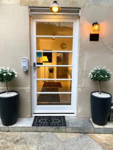 a white door with two potted plants in front of it at Ferndale Mews in Bristol
