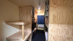 a room with bunk beds and a blue curtain at Fox Glacier Jade Hotel in Fox Glacier