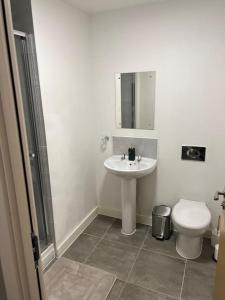 a white bathroom with a sink and a toilet at City scenic view 1 Bedroom apt in Manchester