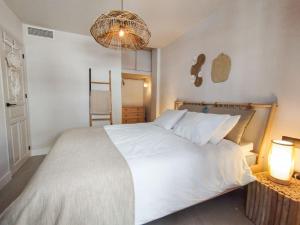 - une chambre avec un grand lit blanc et un lustre dans l'établissement Stunning Apartment with Sea views at Calle Carabeo, Nerja, à Nerja